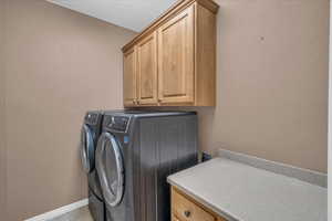 Clothes washing area with cabinets and washer and clothes dryer