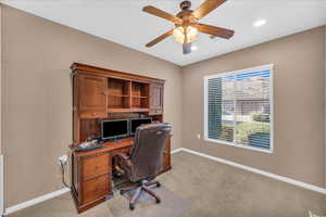 Carpeted office space featuring ceiling fan