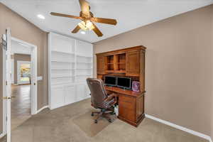 Office area with ceiling fan and light colored carpet