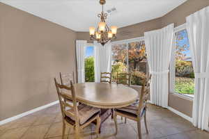 Tiled dining area featuring a notable chandelier