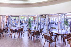 Dining area with wood-type flooring and a high ceiling