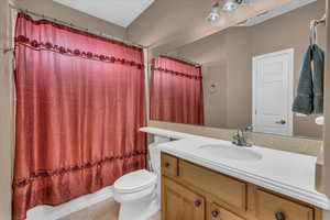 Full bathroom featuring tile patterned floors, vanity, toilet, and shower / bath combo with shower curtain