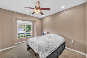 Carpeted bedroom featuring ceiling fan