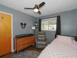 Bedroom with ceiling fan and dark hardwood / wood-style floors