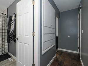 Corridor featuring dark hardwood / wood-style flooring and a textured ceiling