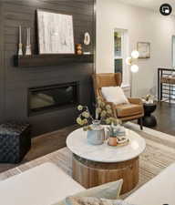 Sitting room with a large fireplace and dark hardwood / wood-style floors