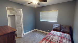 Carpeted bedroom with a textured ceiling, a closet, and ceiling fan