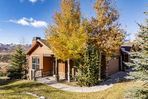 View of property hidden behind natural elements with an outbuilding, a garage, and a front yard