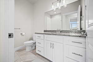 Bathroom with tile patterned flooring, vanity, and toilet