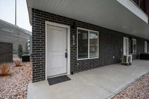 View of exterior entry with central AC unit