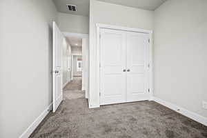 Unfurnished bedroom featuring carpet flooring and a closet