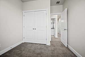 Unfurnished bedroom featuring a closet and carpet floors