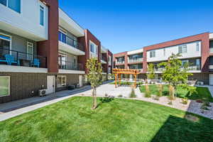 View of community featuring a lawn and a pergola