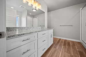 Bathroom with hardwood / wood-style floors, vanity, and an enclosed shower