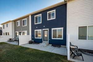 Rear view of house with a lawn and a patio area