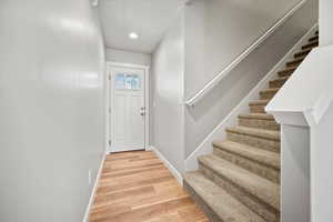 Entryway with hardwood / wood-style flooring and a textured ceiling