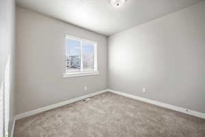 Carpeted empty room featuring a textured ceiling