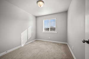 Unfurnished room featuring a textured ceiling and carpet floors