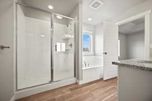 Bathroom featuring separate shower and tub, vanity, and wood-type flooring