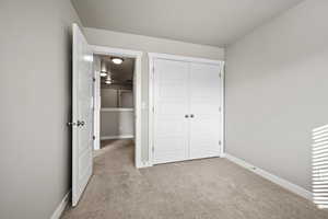 Unfurnished bedroom featuring light carpet and a closet