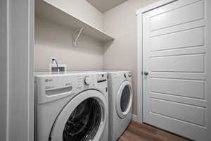 Laundry area with independent washer and dryer and dark wood-type flooring