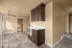 Kitchen with ceiling fan, light hardwood / wood-style floors, dark brown cabinetry, and fridge with ice dispenser