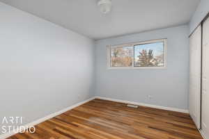 Unfurnished bedroom with hardwood floors and a closet