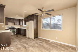 Kitchen featuring appliances with stainless steel finishes, dark brown cabinetry, ceiling fan, sink, and light hardwood / wood-style floors