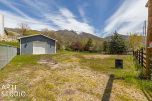 View of yard featuring a mountain view, a garage, and an outdoor structure