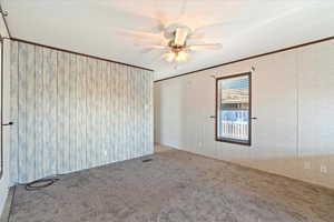 Unfurnished room with crown molding, carpet floors, and ceiling fan