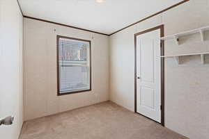 Unfurnished bedroom featuring ornamental molding and light colored carpet