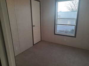 Unfurnished bedroom with light colored carpet