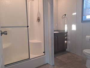 Full bathroom featuring tile patterned flooring, vanity, toilet, and combined bath / shower with glass door