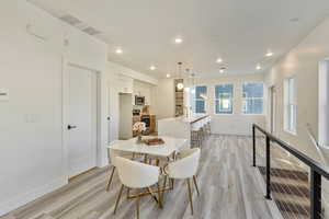 Dining area with sink and light wood-type flooring