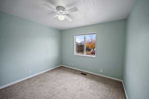 Unfurnished room with ceiling fan, carpet, and a textured ceiling