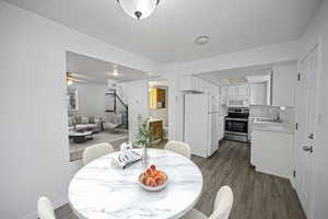 Dining space with a textured ceiling, ceiling fan, dark wood-type flooring, and sink