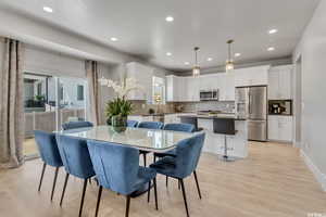 Dining space with light hardwood / wood-style floors and sink