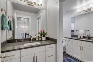 Bathroom with vanity, tile patterned flooring, toilet, a textured ceiling, and a notable chandelier