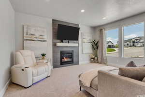 Living room featuring light carpet, a fireplace, and a textured ceiling