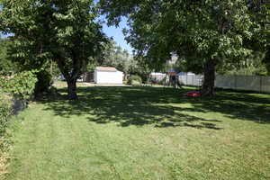 View of yard with a playground, a garage, and an outdoor structure