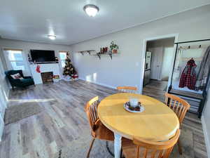 Dining space featuring wood-type flooring and a brick fireplace