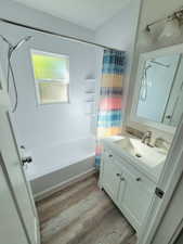 Bathroom with wood-type flooring, vanity, and shower / tub combo