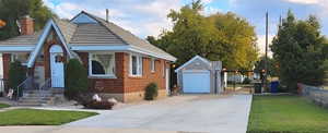 View of front of house with an outbuilding and a garage