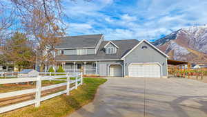 View of front of property with a mountain view, a porch, and a front lawn