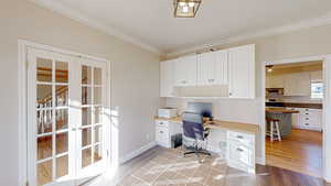 Office space with wood-type flooring, crown molding, and french doors