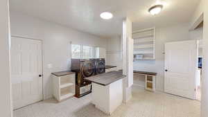 Home office with washing machine and clothes dryer and a textured ceiling