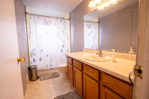 Bathroom featuring vanity, a shower with shower curtain, and toilet