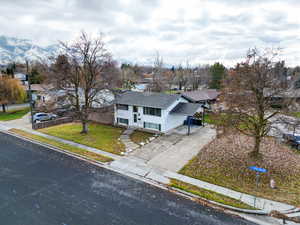 View of front of house featuring a mountain view, a front yard, and a garage