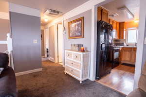 Kitchen with light hardwood / wood-style flooring, black appliances, and sink