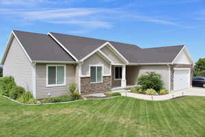 View of front facade featuring a garage and a front yard